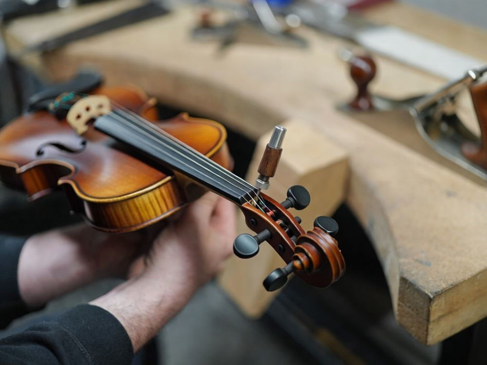 Luthier a ajustar as cravelhas e a ação de um violino Carlo Giordano na 906.pt